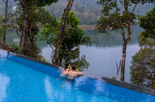 Infinity swimming pool overlooking lake and greenery at Terrace Resorts